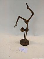 Front and angled side view of the brass gymnastics statue showing the figure and base clearly