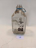 Front view of the vintage Hogan's Dairy half gallon milk bottle showing the printed logo and metal swing-top closure.