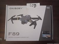 Box of Chusory F89 micro foldable drone set showing drone, branding, age recommendation, and remote control image, indicating the product contents and usage.