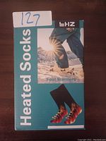 ZH Heated Socks box with image showing heated foot warmers and person outdoors in snow.