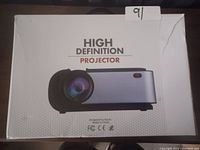 Box featuring an image of the high definition projector with black and silver casing, labeled 'High Definition Projector'.