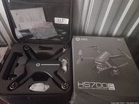 Holy Stone HS700E drone and case with accessories displayed alongside retail box.