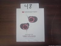 White retail box containing Monster Achieve 100 AirLinks wireless earbuds, showing front of packaging with product image and branding.