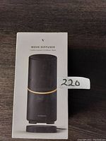 Front of product box showing black Vitruvi Move diffuser image, model name, and branding