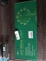 Green Semai LED grow light box with product features including remote control, full spectrum dimmable light, adjustable height, 480 LEDs, 40W power, and tripod stand, labeled model AC-01.