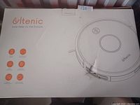 Photo of the white and orange Ultenic robotic vacuum box showing the vacuum's top view and key features icons.