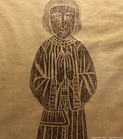 Close-up of the brass rubbing-style artwork showing the figure details on textured gold-coloured paper.