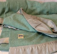 Wool blanket with satin edge folded to show label and fabric texture