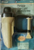 Front view showing the Attwood portable bow light in original sealed packaging, light unit and universal clamp visible.