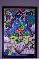 Full view of the Alice In Wonderland blacklight print in black frame with neon colors and characters including the White Rabbit, Caterpillar, Cheshire Cat, Mad Hatter, and playing cards