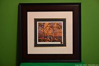 Full view of the framed print showing the landscape art inside a dark wood frame with white and dark inner mats.