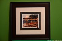 Full view of the framed print displayed against a green wall, showing the overall framing and presentation.