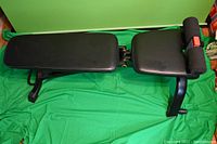 Full view of bench in flat position showing back pad, seat pad, foam leg rollers and frame