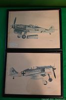 Photo of both framed prints showing Messerschmitt Bf 109 and Focke-Wulf Fw 190 in black frames on green surface