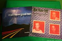 Photo of the two vinyl album covers placed side-by-side on a green surface: Ben Folds Five - Whatever and Ever Amen and Matthew Good Band - Beautiful Midnight.