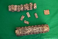 Full view of all 55 bone domino pieces displayed with the original decorated bone case.