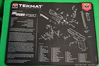 Black neoprene Tekmat designed for Sig Sauer P320 disassembly and cleaning with detailed exploded parts diagram and parts list printed in white.