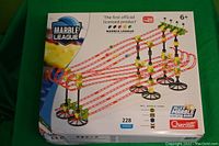 Box of the Quercetti Jelles Marble League Marble Racing Set showing a multi-level marble racing track with the logo, piece count, and team marbles shown.