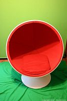 Front view of chair showing red fabric interior and white pedestal base