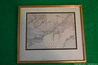 Framed vintage map of Upper and Lower Canada shown whole against green background. The frame is gold tone wood with double matting in beige and black.