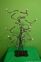 Front view of vintage metal wire wine and bottle holder with round wooden tips and flat base