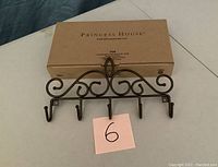 Front view of one Princess House Meridian metal wall organizer with five hooks, showing decorative scroll design and original box.