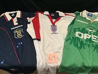 Three soccer jerseys laid out showing Scotland (blue), England (white), and Ireland (green) jerseys