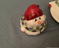 Close-up of Fitz and Floyd snowman ceramic bowl showing red hat and purple-green checkered scarf details.