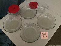 Set of 8 Princess House Fantasia glass bowls arranged on a table with two smaller bowls having red fabric covers.
