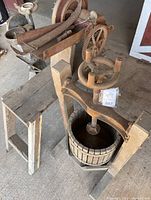 Angled top view of wooden cider press showing cast iron screw assembly and slatted basket