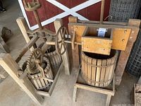 Overview of both antique cider presses side by side in wooden frames