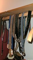 View of six hanging belts showing different materials and colors