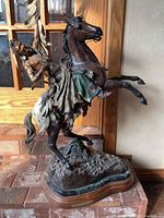 Frontal view of entire bronze sculpture showing rider and horse
