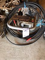 Image of Excell pressure washer with 2750 PSI rating on control panel, wrapped hose, and exposed engine parts.