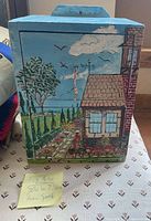 Front view of box showing seaside garden and cottage scene