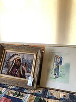 Overall shot showing both framed artworks side by side on quilted surface