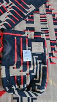 Folded blanket with matching bag and suede patch visible