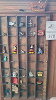 Wooden cubby shelf filled with small figurines including Mickey and Minnie, ceramic sheep, glass objects