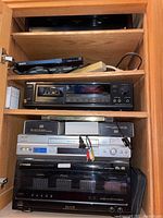 Full cabinet view showing two stacked Sony TA-N55ES stereo power amplifiers at top, Sony DVD player below, cassette deck, VHS VCR and Pioneer Elite CD changer at bottom.