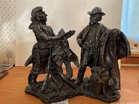 Front view of the bronze sculpture showing both figures and base.