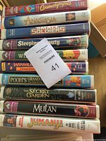 Photo showing the stacked VHS tape cases of the 10 children's movies with titles visible.