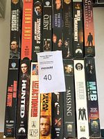 All 16 VHS movies arranged showing titles on spine and front covers in a single stack.