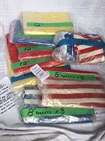 Catalog photo showing the folded and sealed packaging of various table cloths and runners labeled with lengths.