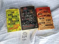 Three paperback books from The Millennium Series by Stieg Larsson laid out side by side showing front covers.