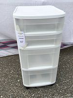 Front view of white plastic storage cart with four drawers.
