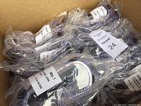 Photo showing a box filled with individually wrapped economy goggles with labels.