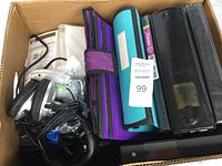 Box containing multiple office items including headphones, file folders, and electronics in a cardboard box.