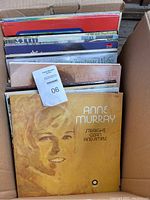 Box with vinyl record albums showing Anne Murray's 'Straight Clean and Simple' album on top.