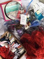 Overview photo showing assorted sewing supplies, threads, ribbons, small tools, and packaged fabric pieces in various colors