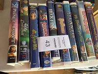 Photo showing spine labels of 10 children's VHS movies in a row: The Prince of Egypt, Fievel Goes West, A Simple Wish, TuggaMonas, The Adventures of Huck Finn, Atlantis, My Favorite Martian, Air Strike, The Hunchback of Notre Dame, The Joy Luck Club.